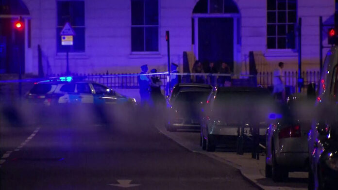 Police officers stand behind a cordon after a knife attack in London on Thursday.Photo: Sky News / Associated Press
