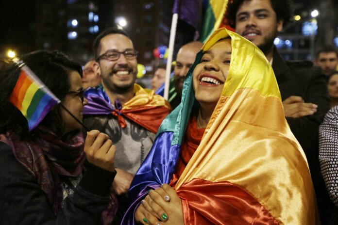 People celebrate in a park as they listen to the announcement from Havana, Cuba, that delegates of Colombia's government and leaders of the Revolutionary Armed Forces of Colombia reached a peace accord to end their half-century civil war, in Bogota, Colombia, Wednesday, Aug. 24, 2016.