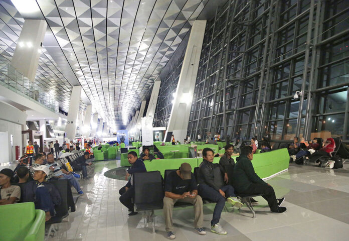 Passengers wait Tuesday for their flights on the first day of operation of the new terminal of Soekarno-Hatta International Airport on the outskirts of Jakarta, Indonesia. Photo: Tatan Syuflana / Associated Press