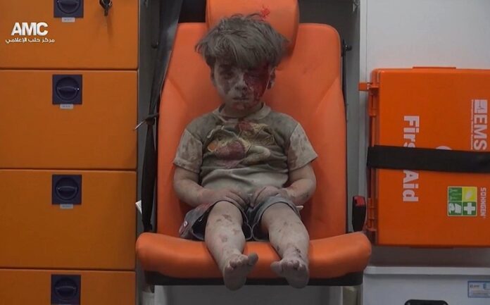 In this frame grab taken from video provided by the Syrian anti-government activist group Aleppo Media Center (AMC), a child sits in an ambulance after being pulled out or a building hit by an airstirke, in Aleppo, Syria, Wednesday.
