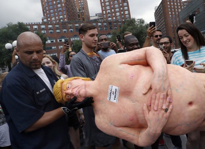 An employee of the New York City Department of Parks and Recreation removes a statue of a naked Republican presidential candidate Donald Trump on Thursday at the New York's Union Square. Photo: Mary Altaffer / Associated Press