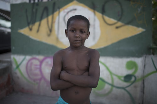 A kid poses in the Mangueira slum next to the Maracana Stadium that is hosting the Rio's 2016 Summer Olympics opening ceremonies on Friday in in Rio de Janeiro. Photo: Leo Correa / Associated Press
