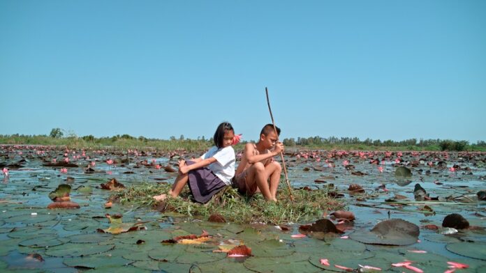 A boy and a girl among lotus blossoms in ‘The Forest.’ Photo: The Forest / Courtesy