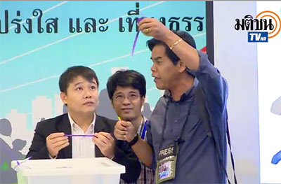 A photographer demonstrates the ballot box security strap he was able to rip off with his bare hands.