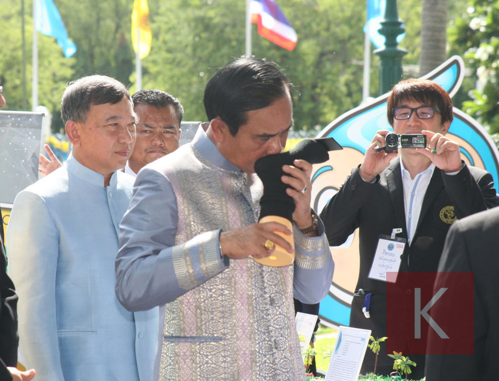 Junta chairman Prayuth Chan-ocha smells a sock at an exhibition Tuesday at Government House in Bangkok.