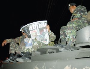 ‘COUP!’ reads the front page of a Khaosod newspaper read by soldiers atop a tank on Sept. 20, 2006, one day after the military staged a coup against then-PM Thaksin Shinawatra.