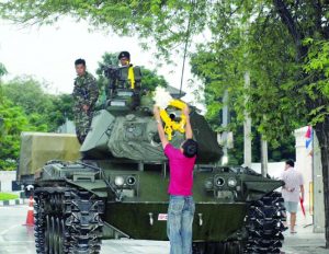 A man hangs garlands on a tank Sept. 22, 2006, in Bangkok.