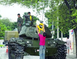 A man hangs garlands on a tank Sept. 22, 2006, in Bangkok. 