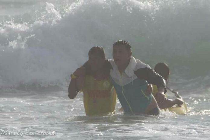 Lifeguard Chaiwut Singsom, at left, saves a Chinese tourist swept out to sea Sunday from Kata Beach on Phuket. Photo: David Tawan / Courtesy
