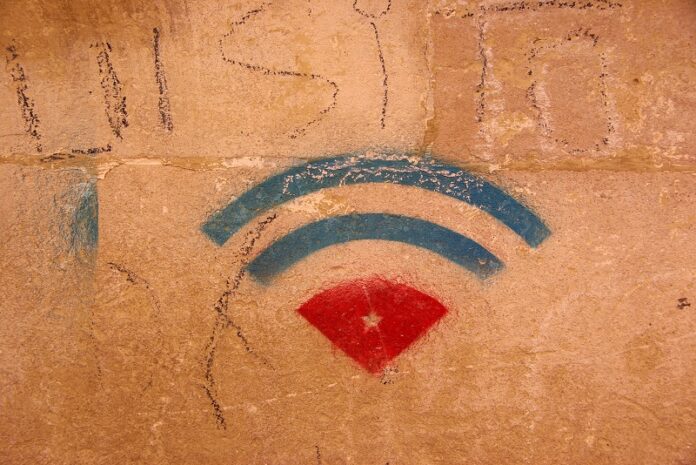 A WiFi symbol juxtaposed with a Cuban flag is shown on graffiti art in 2014 in the streets of Havana, Cuba. Photo: Eric Vernier / Flickr