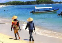 Australian Woman Detained in Bali on Suspicion of Journalism Residents walk on Nusa Dua Beach in 2015 in Bali, Indonesia. Photo: Thomas Depenbusch / Flickr
