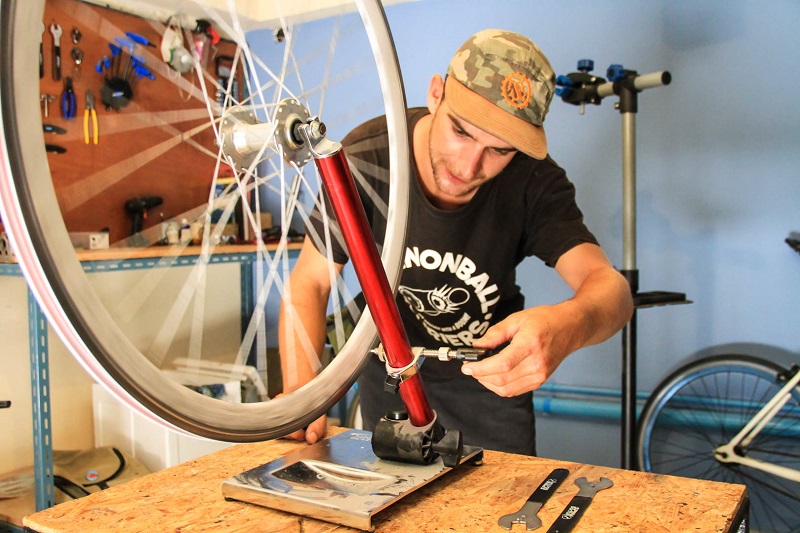 New York bike messenger Bryan Boor showing how to true a bike wheel at Don Kuson Community Bike Shop