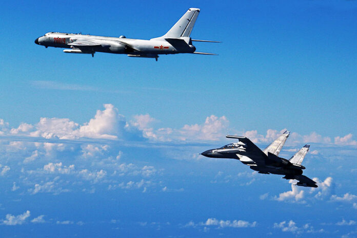 A Chinese People's Liberation Army Air Force Su-30 fighter, at right, flies along with a H-6K bomber as they take part in a drill near the East China Sea in a photo released Sunday. Photo: Shao Jing / Xinhua / Associated Piress. Chinese Air Force