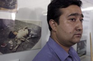 A Uighur official stands near a picture of a dead separatist militant at an exhibition in 2003 China's western Xinjiang province. Photo: Ng Han Guan / Associated Press