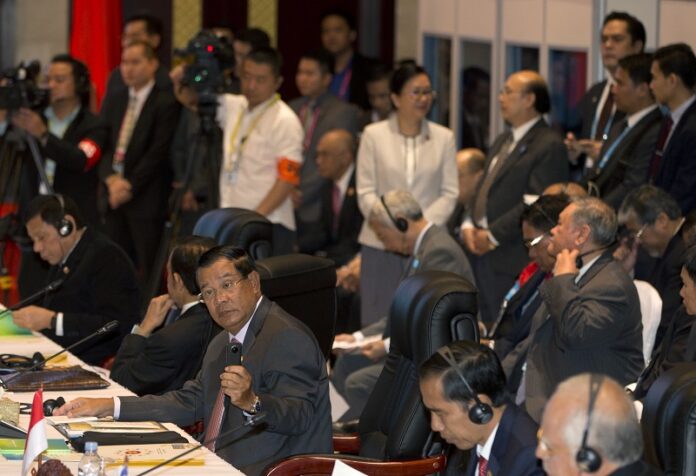 Cambodia's Prime Minister Hun Sen, left takes photos during 19th ASEAN-China summit, a parallel summit in the ongoing 28th and 29th ASEAN Summits and other related summits on Wednesday at the National Convention Center in Vientiane, Laos. Photo: Gemunu Amarasinghe / Associated Press