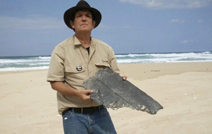 Blaine Gibson holds a piece of aircraft debris Sept. 16 on a beach in Madagascar. Photo: Blain Gibson / Associated Press