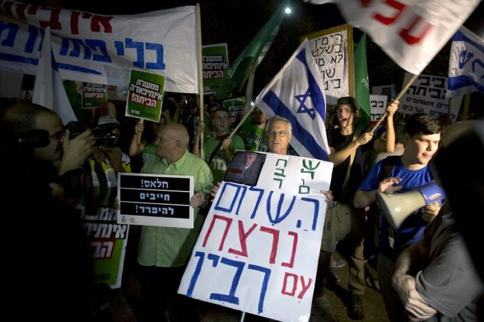 FILE -- In this Oct. 24, 2015 file photo, Israeli left wing activists hold signs during a peace rally Oct. 2015 in Tel Aviv, Israel. Photo: Sebastian Scheiner / Associated Press
