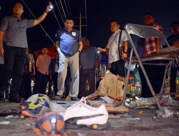 Philippine President Rodrigo Duterte, second left, on Saturday visits the site of the previous night's explosion that killed more than a dozen people and wounded others at a night market in Davao city, his hometown. Photo: Robinson Ninal / Philippines Government / Associated Press