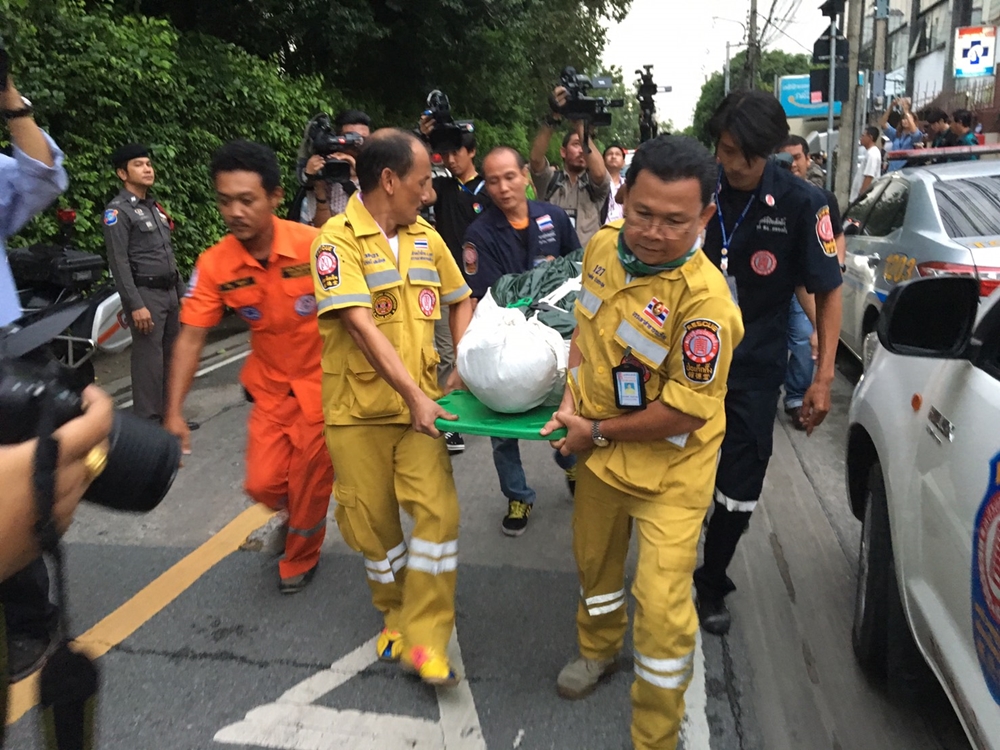 Rescue workers on Friday carry the dead body from a building in Bangkok’s Phra Khanong area.