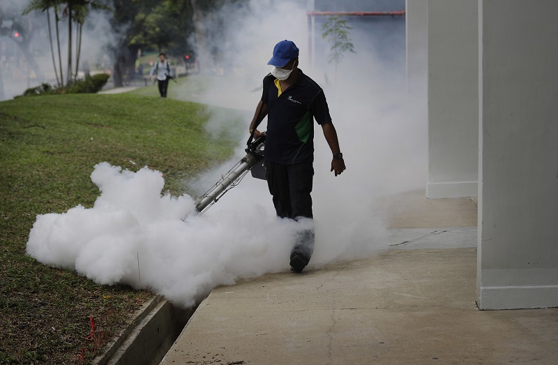 A pest control worker fumigates drains at a local housing estate in Singapore where the latest case of Zika infections were reported on Thursday. Photo: Wong Maye-E / Associated Press