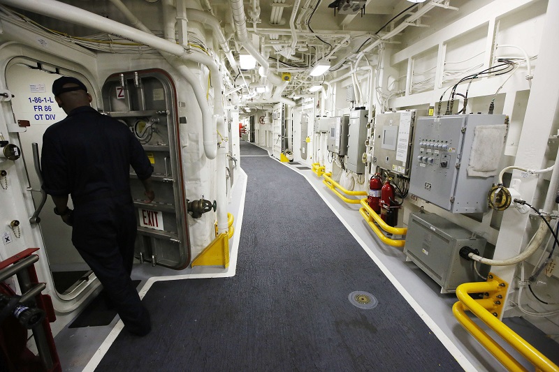 A sailor enters a doorway on the USS Zumwalt while at dock Friday at the naval station in Newport, United States. Photo: Michael Dwyer / Associated Press