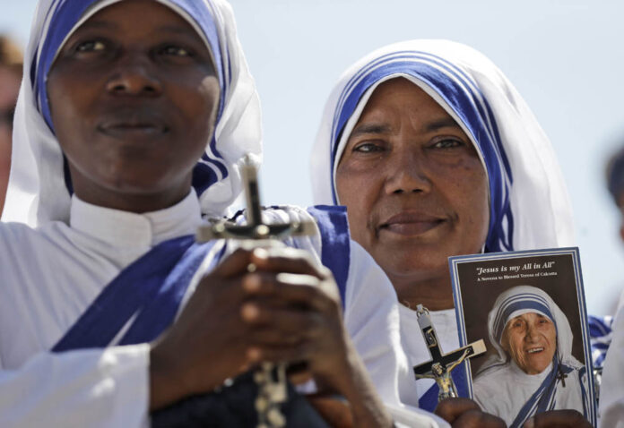 Missionaries of Charity nuns hold a photo of Mother Teresa in St. Peter's Square at the Vatican on Saturday during a jubilee audience for workers and volunteers of mercy led by Pope Francis. Photo: Alessandra Tarantino / Associated Press