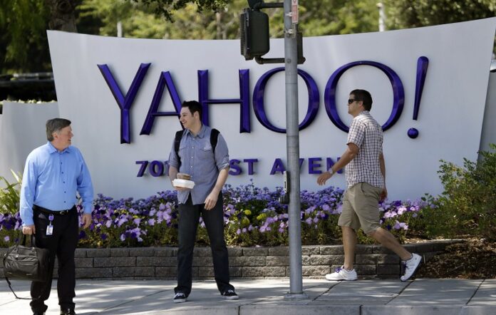 People walk in front of a Yahoo sign in 2014 at the company's headquarters in Sunnyvale, Calif. Photo: Marcio Jose Sanchez / Associated Press