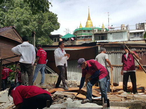 City workers dismantle one of a dozen homes inside the Pom Mahakan community Saturday in Bangkok.