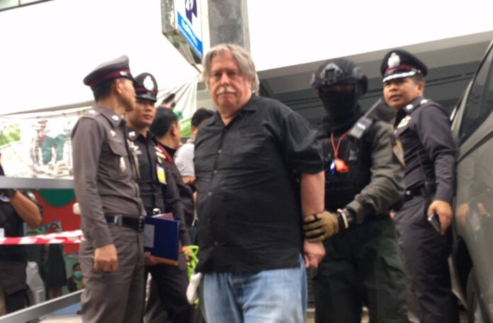 One of the unnamed suspects is escorted out of the building by police.