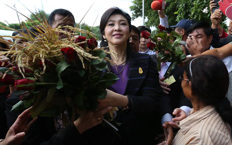 Former PM Yingluck Shinawatra on Jan. 15 receives a bundle of rice from her supporters outside court just before her trial on charges of negligence commences. 