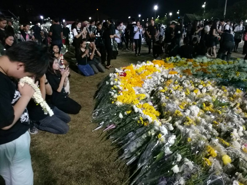 Flowers accumulate Thursday evening outside the Grand Palace in Bangkok.