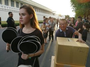 Former teen idol and fitness program host Thanchanok 'Bebe' Ritnaka hands out fans Thursday at the Grand Palace in Bangkok.