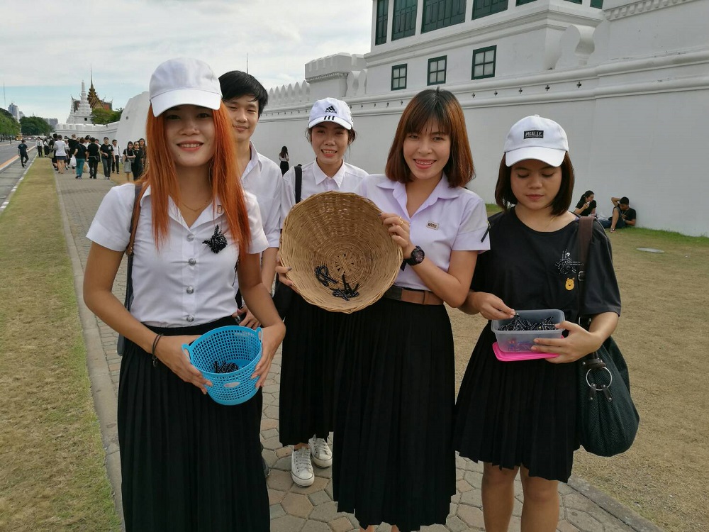 Students run out of hand-made black ribbons they were handing out Thursday outside the Grand Palace in Bangkok.