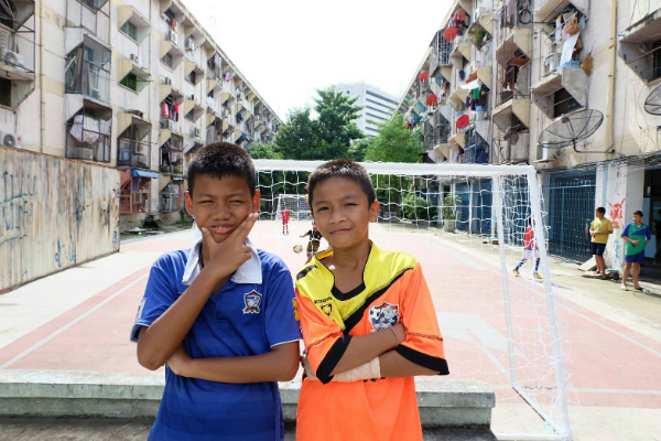 Wiliyak ‘Pai’ Phromjan, 10, and his friend Phuwanat ‘Mike’ Piangtakoe, 12, on the soccer field between flats 1 and 2. 