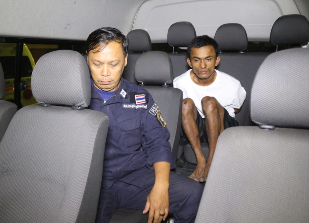 A Burmese man named “Jimmy” or “Bung” sits in a police van on Saturday morning shortly after his arrest in Pathum Thani province.