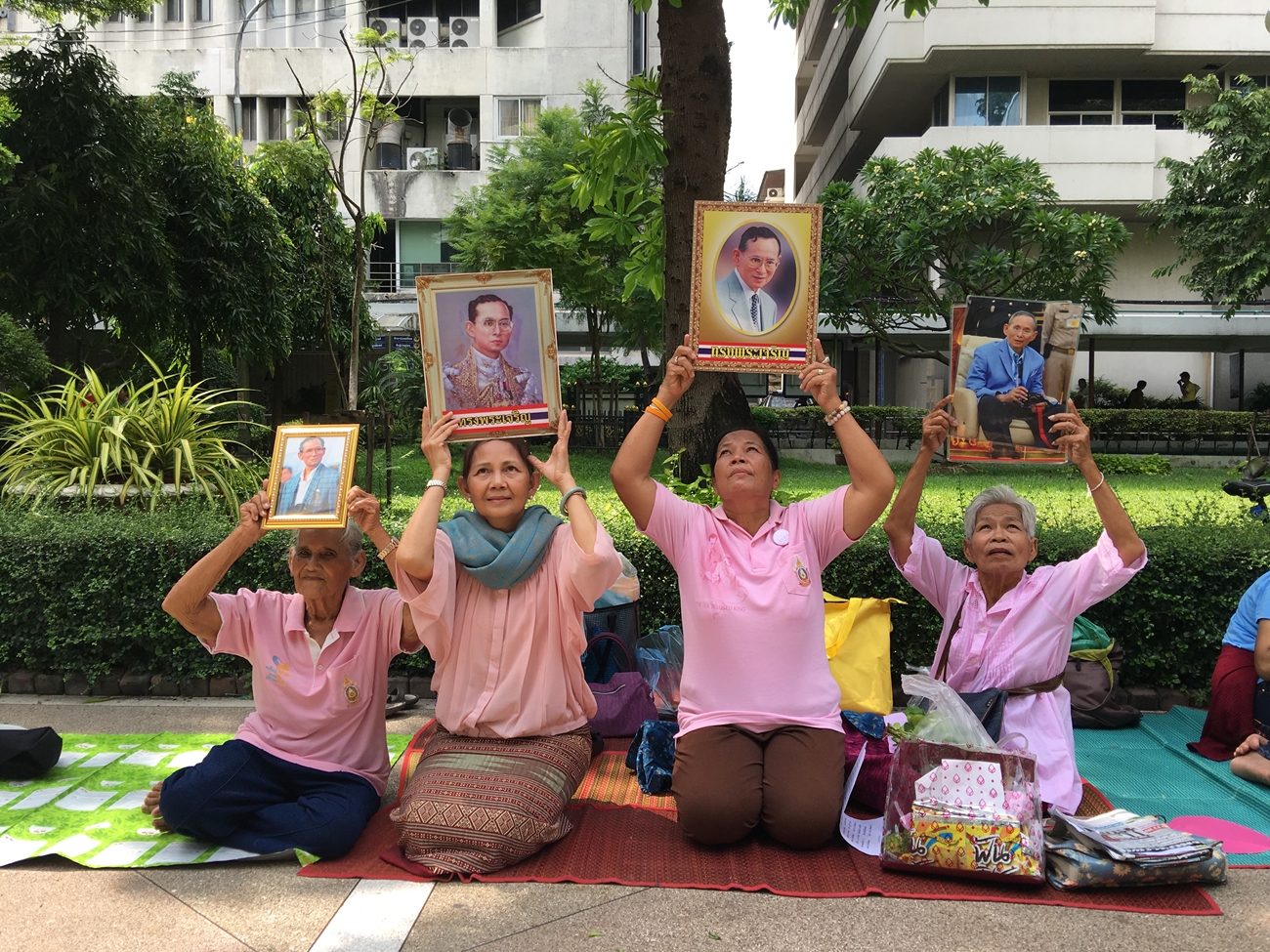 Holding portraits of His Majesty the King, well-wishers camp out on Wednesday to pray for King Bhumibol at Siriraj Hospital in Bangkok.