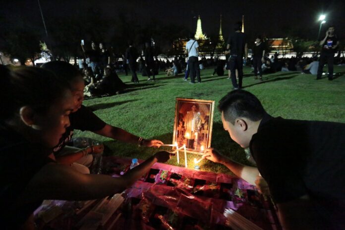 Mourners light candles Saturday at the Sanam Luang in Bangkok.