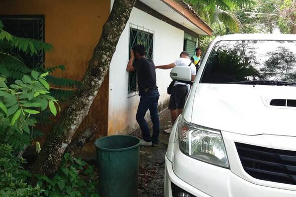 Police and community members Sunday in front of the home of a man accused of defaming the monarchy.