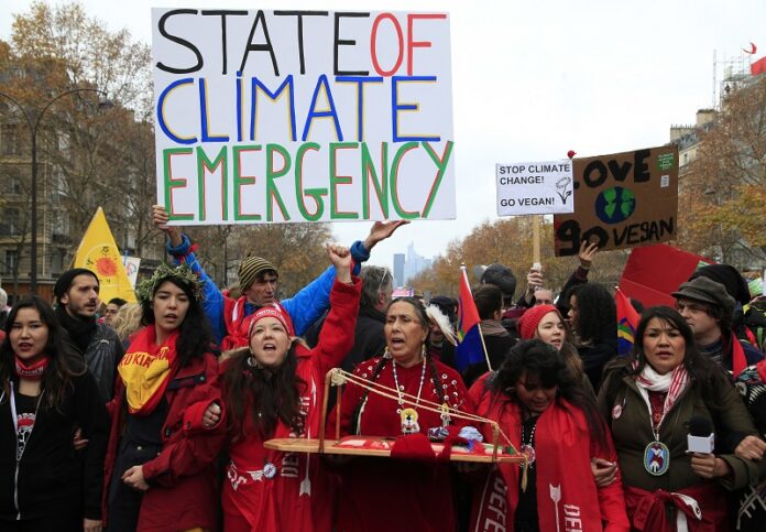 Climate activists demonstrate in 2015 during COP21, the United Nations Climate Change Conference, in Paris, France. Photo: Thibault Camus / Associated Press