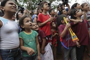 Children from the Rio da Casca community react to seeing an elephant for the first time, as they watch the convoy transporting Asian elephants Maia and Guida to their new home in Chapada dos Guimaraes, Brazil. Photo: Eraldo Peres / Associated Press