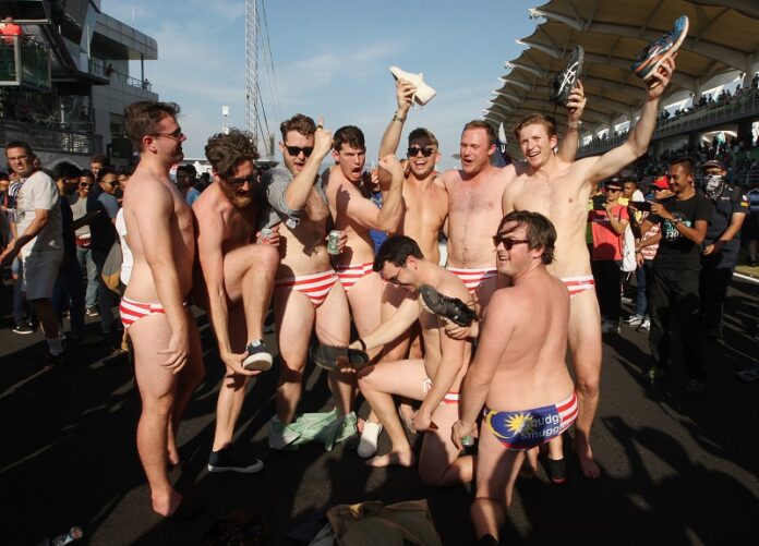 Australian men celebrate in Budgy Smuggler-brand swimsuits decorated with the Malaysian flag Sunday at the conclusion of the Malaysian Formula One Grand Prix in Sepang, Malaysia. Photo: Associated Press