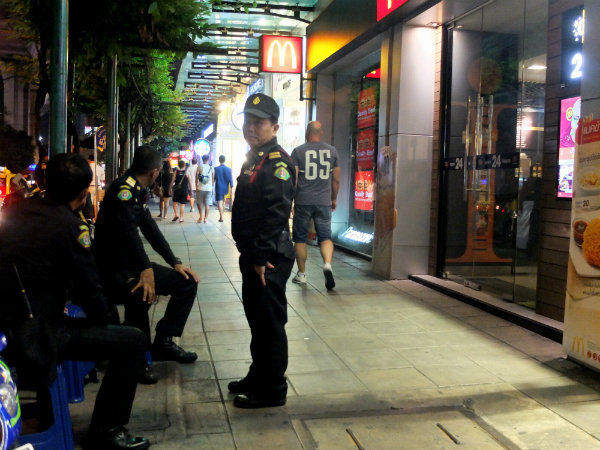 Municipal ‘tessakit’ officers watch over sidewalks Wednesday night in the Nana area of Sukhumvit Road.