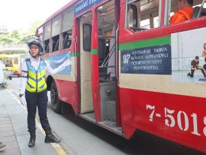 Patchara Sotnirunchai directs people to a free shuttle bus to the Grand Palace on Friday where the funeral bathing ceremony for HM the King was to take place.