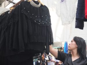 A customer shops for black shirts Friday at Victory Monument in Bangkok.