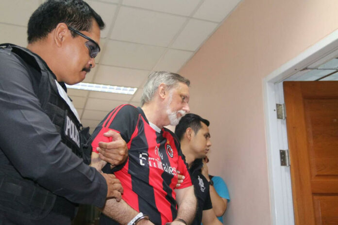 Herbert La Fon, 63 of the United States, is led from an interrogation session Friday in Bangkok.