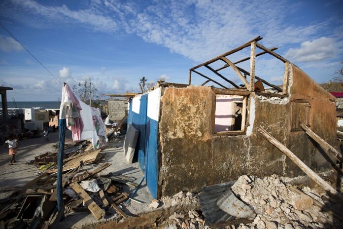 A girl walks in front of a house that was destroyed by Hurricane Matthew Monday in Dame-Marie, Haiti. Photo: Dieu Nalio Chery / Associated Press