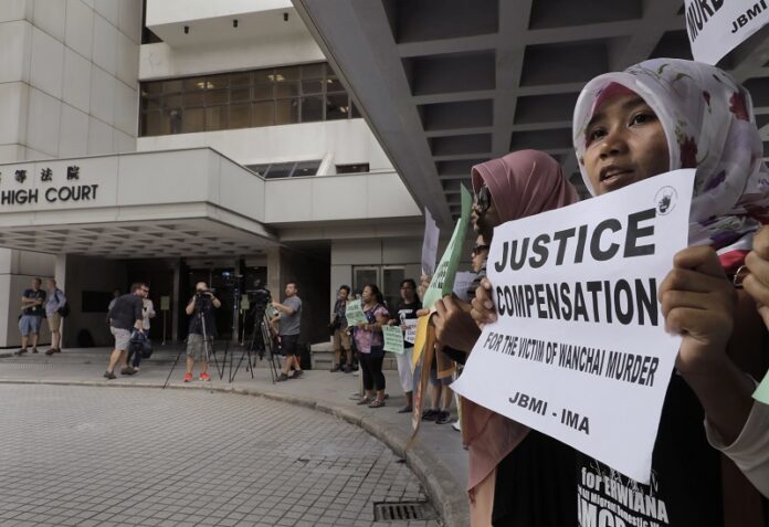 A migrant workers alliance group holds placards last October to protest the killings of two Indonesian women in 2014 outside the High Court in Hong Kong. Photo: Vincent Yu / Associated Press