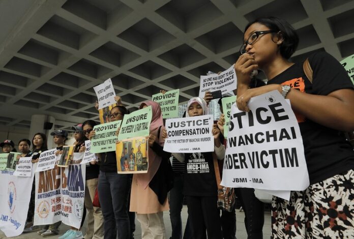 A migrant workers alliance group holds placards to protest the killings of two Indonesian women in 2014 outside the High Court in Hong Kong. Photo: Vincent Yu / Associated Press