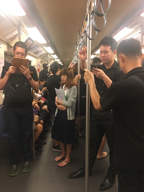 Commuters in black and white Friday aboard the BTS Skytrain. 
