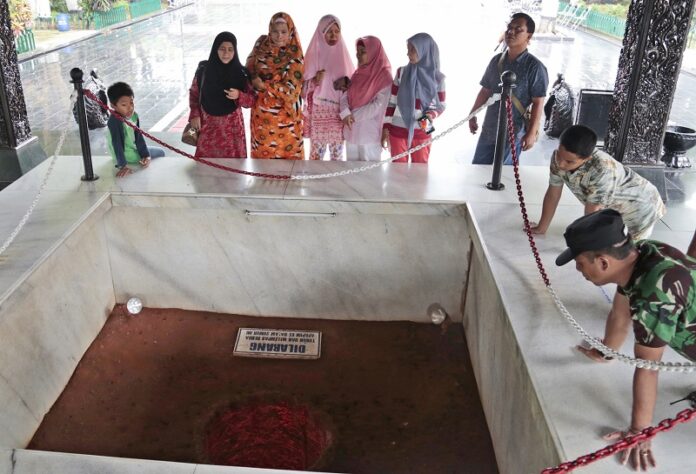 Visitors look at an old well where six Indonesian Army generals were buried after being killed in an abortive coup in 1965 that the military blamed on Indonesia’s Communist Party, Friday at Pancasila Sakti Monument in Jakarta, Indonesia. Photo: Dita Alangkara / Associated Press
